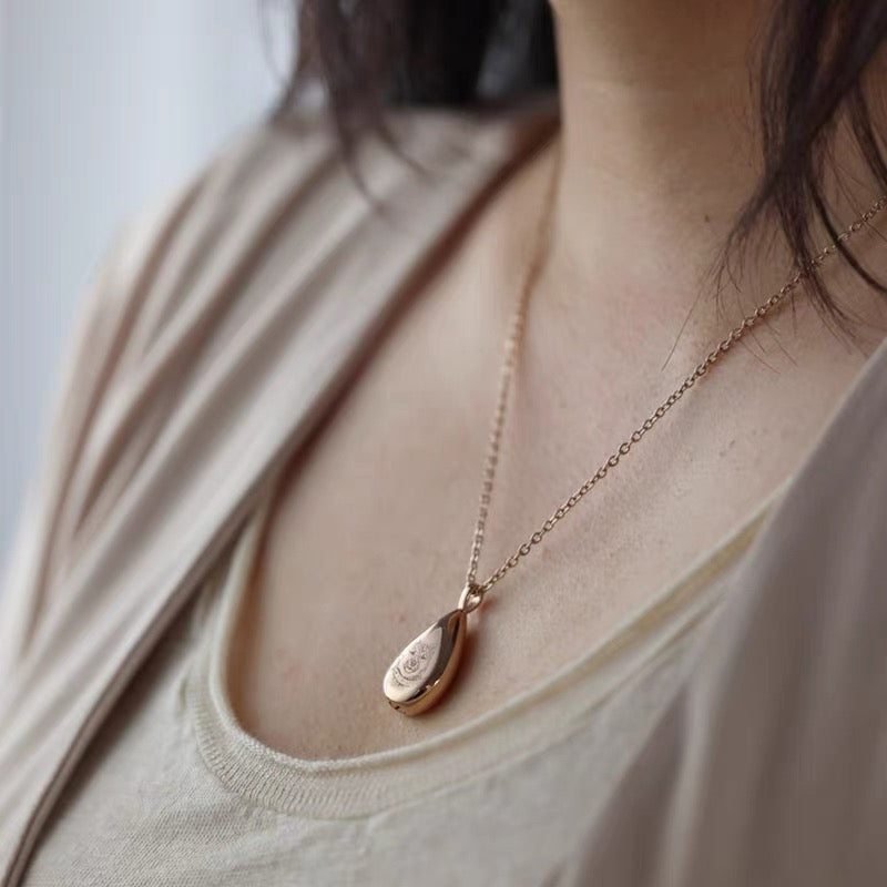 Rose gold necklace with a teardrop pendant worn by a person Memorial Jewelry