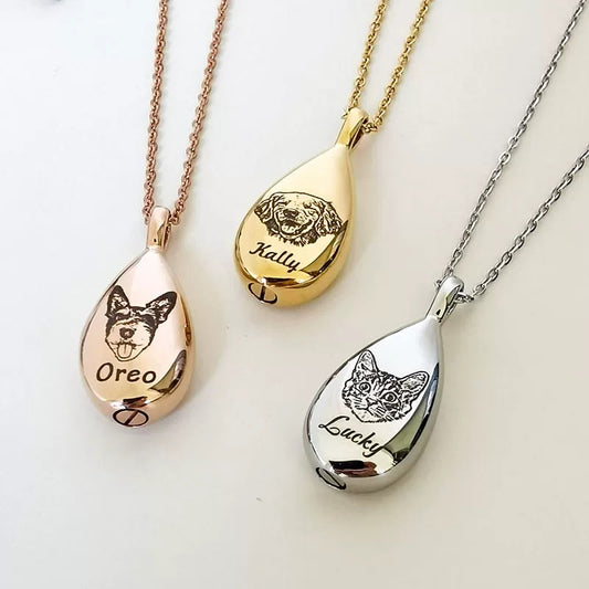 Three teardrop-shaped pet memorials with engraved dog faces and names on rose gold, gold, and silver chains.